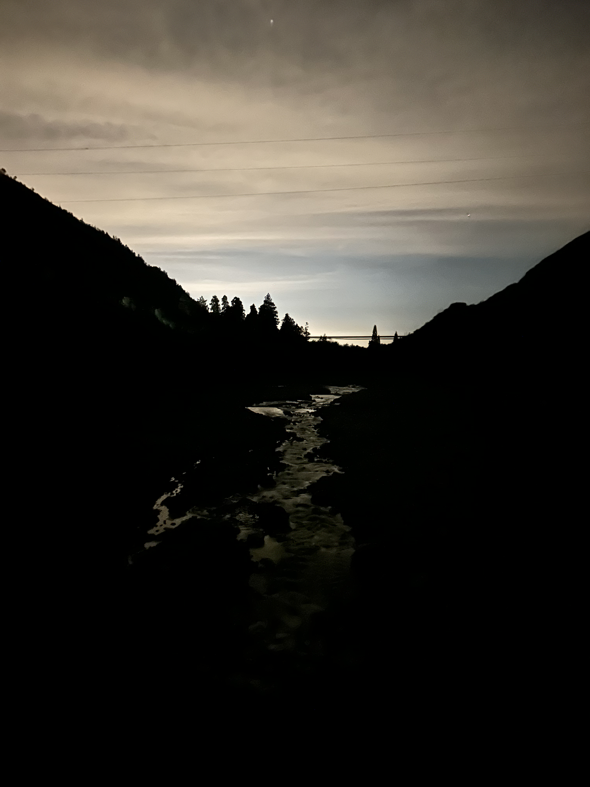 Mountain valley at twilight, silhouettes against fading sky